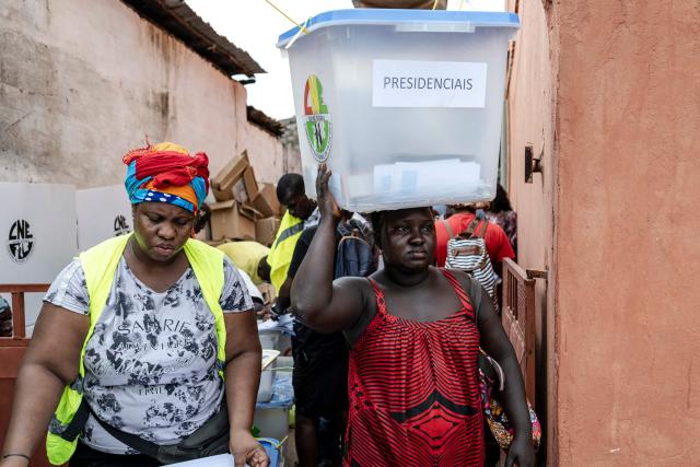 TOPSHOT - An official from the National Electoral Commission (CNE) carries a ballot box full of electoral materials on her head at their regional offices in Gabu, on November 22, 2025, on the eve of Guinea-Bissau’s general elections. Guinea-Bissau votes in general elections on November 23, 2025. (Photo by PATRICK MEINHARDT / AFP)