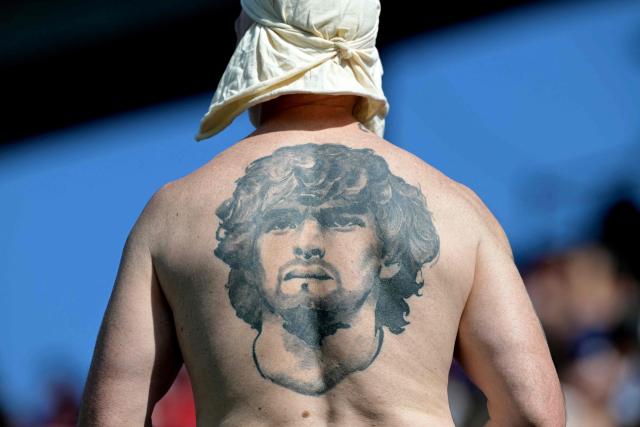 A fan of Lanus bearing a tattoo depicting the late football legend Diego Armando Maradona waits for the start of the Copa Sudamericana final football match between Argentina's Lanus and Brazil's Atletico Mineiro at the Defensores del Chaco stadium in Asuncion on November 22, 2025. (Photo by JUAN MABROMATA / AFP)