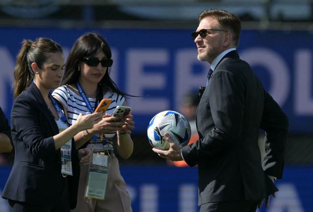 Conmebol's president, Paraguayan Alejandro Dominguez stands holding the official ball for the Copa Sudamericana final football match between Argentina's Lanus and Brazil's Atletico Mineiro at the Defensores del Chaco stadium in Asuncion on November 22, 2025. (Photo by JUAN MABROMATA / AFP)
