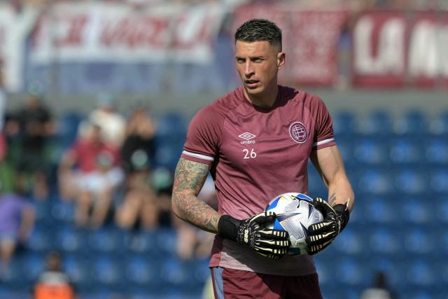 Lanus' goalkeeper #26 Nahuel Losada grabs a ball during the warm-up before the start of the Copa Sudamericana final football match between Argentina's Lanus and Brazil's Atletico Mineiro at the Defensores del Chaco stadium in Asuncion on November 22, 2025. (Photo by JUAN MABROMATA / AFP)