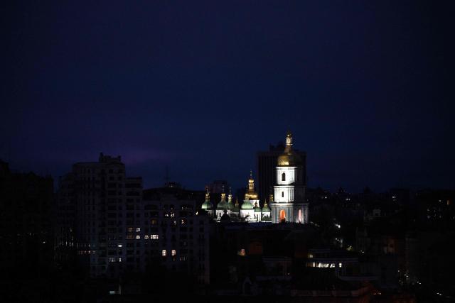 This photograph shows the illuminated St. Sophia Cathedral with residential buildings in the background during a power outage in Kyiv, on November 22, 2025, amid the Russian invasion of Ukraine. (Photo by Sergei GAPON / AFP)