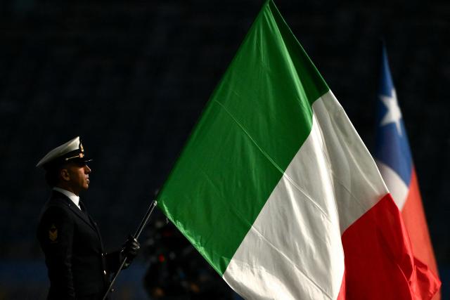 An Italian Navy officer holds Italy's national flag ahead of the Autumn Nations Series international rugby union test match between Italy and Chile at Stadio Luigi Ferraris stadium in Genoa, on November 22, 2025. (Photo by MARCO BERTORELLO / AFP)