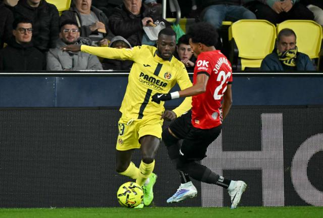 Villarreal's Ivorian forward #19 Nicolas Pepe fights for the ball with Real Mallorca's Colombian defender #22 Johan Mojica during the Spanish league football match between Villarreal CF and RCD Mallorca at La Ceramica Stadium in Vila-real on November 22, 2025. (Photo by JOSE JORDAN / AFP)