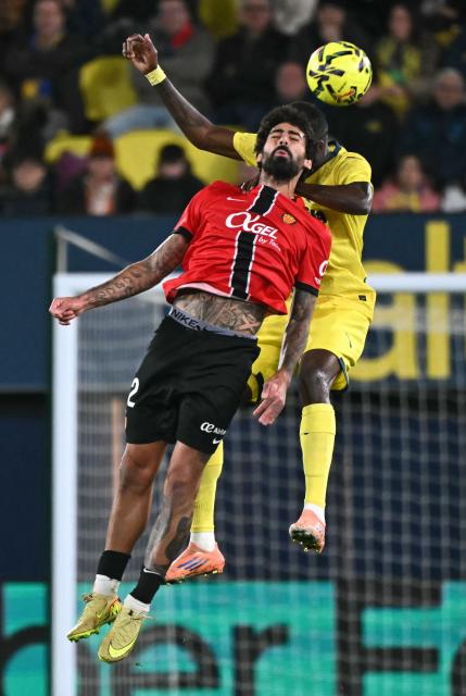 Real Mallorca's Portuguese midfielder #12 Samuel Costa and Villarreal's Ghanaian midfielder #16 Thomas Partey vie for a header during the Spanish league football match between Villarreal CF and RCD Mallorca at La Ceramica Stadium in Vila-real on November 22, 2025. (Photo by JOSE JORDAN / AFP)