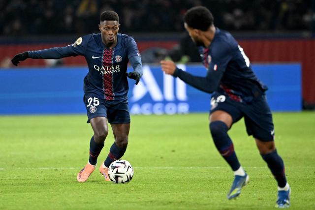 Paris Saint-Germain's French forward #49 Ibrahim Mbaye (R) rushes as Paris Saint-Germain's Portuguese defender #25 Nuno Mendes (L) prepares to pass the ball during the French L1 football match between Paris Saint-Germain (PSG) and Le Havre AC at the Parc des Princes stadium in Paris, on November 22, 2025. (Photo by Bertrand GUAY / AFP)