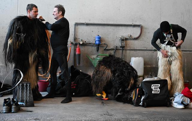 Participants get dress up as traditional folkloric figure "Krampus", as they prepare to take part in the traditional parade during the "Night of Hell" in Lana, northern Italy, on November 22, 2025. An old tradition that takes place in the Alps of Tirol northern Italy, the traditional Krampus creature (half-goat, half-demon figure) punishes people who misbehaved during Christmas season. (Photo by Stefano RELLANDINI / AFP)