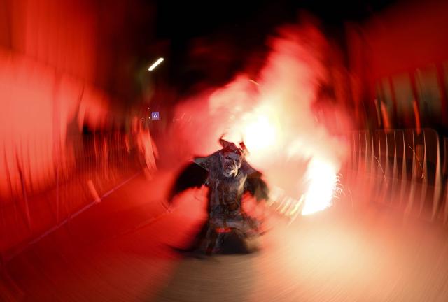 A reveller dressed as traditional folkloric figure "Krampus", takes part in the traditional parade during the "Night of Hell" in Lana, northern Italy, on November 22, 2025. An old tradition that takes place in the Alps of Tirol northern Italy, the traditional Krampus creature (half-goat, half-demon figure) punishes people who misbehaved during Christmas season. (Photo by Stefano RELLANDINI / AFP)