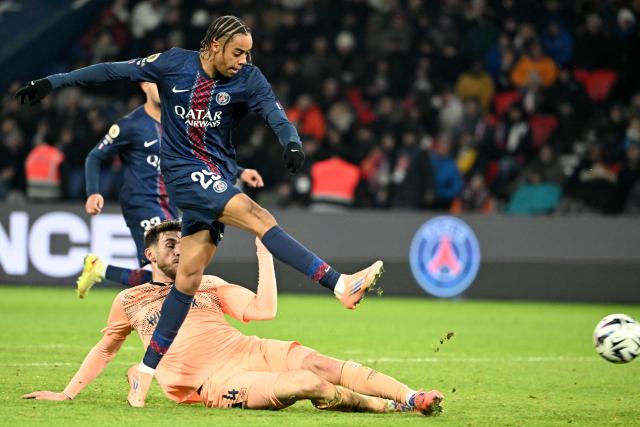 Paris Saint-Germain's French forward #29 Bradley Barcola (top) shoots to score a goal despite Le Havre's French defender #04 Gautier Lloris during the French L1 football match between Paris Saint-Germain (PSG) and Le Havre AC at the Parc des Princes stadium in Paris, on November 22, 2025. (Photo by Bertrand GUAY / AFP)