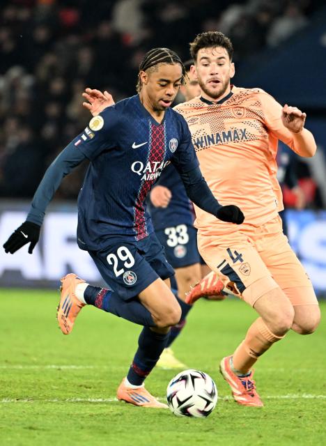 Paris Saint-Germain's French forward #29 Bradley Barcola (L) vies with Le Havre's French defender #04 Gautier Lloris (R) during the French L1 football match between Paris Saint-Germain (PSG) and Le Havre AC at the Parc des Princes stadium in Paris, on November 22, 2025. (Photo by Bertrand GUAY / AFP)