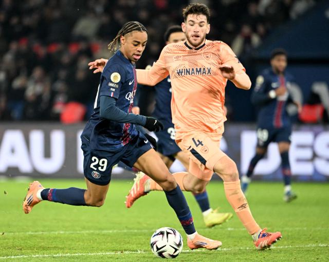 Paris Saint-Germain's French forward #29 Bradley Barcola (L) vies with Le Havre's French defender #04 Gautier Lloris (R) during the French L1 football match between Paris Saint-Germain (PSG) and Le Havre AC at the Parc des Princes stadium in Paris, on November 22, 2025. (Photo by Bertrand GUAY / AFP)
