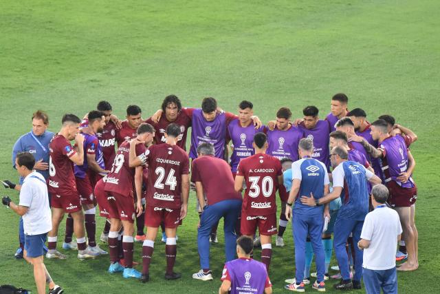 Lanus' players gather in circle ahead of the extra time of the Copa Sudamericana final football match between Argentina's Lanus and Brazil's Atletico Mineiro at the Defensores del Chaco stadium in Asuncion on November 22, 2025. (Photo by JOSE BOGADO / AFP)