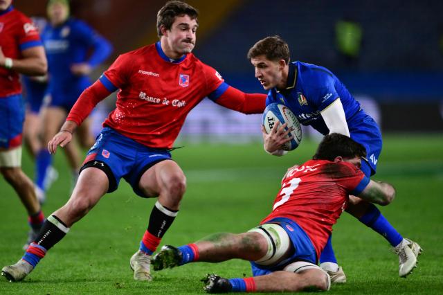 Italy’s scrum-half Martin Page-Relo (R) is tackled during the Autumn Nations Series international rugby union test match between Italy and Chile at Stadio Luigi Ferraris stadium in Genoa, on November 22, 2025. (Photo by Marco BERTORELLO and MARCO BERTORELLO / AFP)