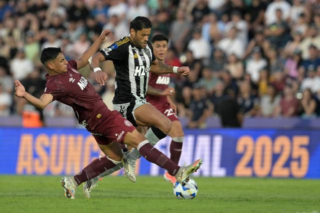 Lanus' midfielder #30 Agustin Cardozo (L) and Atletico Mineiro's forward #07 Hulk (R) fight for the ball during the Copa Sudamericana final football match between Argentina's Lanus and Brazil's Atletico Mineiro at the Defensores del Chaco stadium in Asuncion on November 22, 2025. (Photo by Juan MABROMATA / AFP)