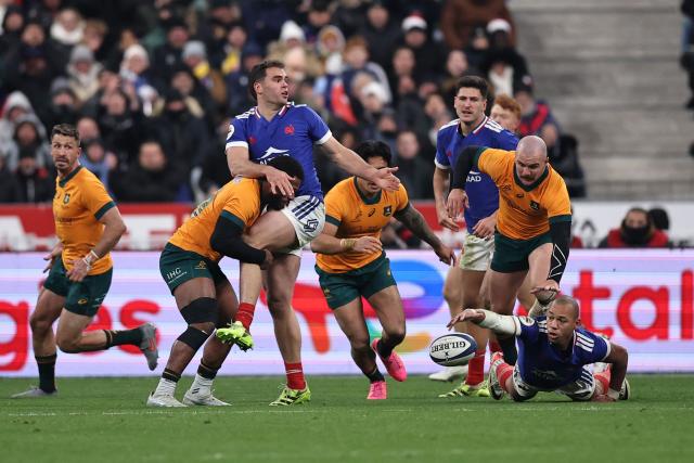 France's wing #14 Damian Penaud (L) passes to France's centre #12 Gael Fickou (R) as he is tackled  during the Autumn Nations Series international rugby union test match between France and Australia at the Stade de France in Saint-Denis, north of Paris, on November 22, 2025. (Photo by Anne-Christine POUJOULAT / AFP)