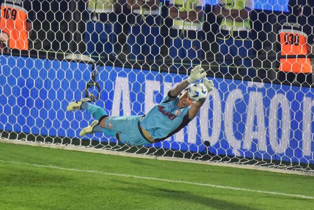 Lanus' goalkeeper #26 Nahuel Losada makes a save during the penalty shootout of the Copa Sudamericana final football match between Argentina's Lanus and Brazil's Atletico Mineiro at the Defensores del Chaco stadium in Asuncion on November 22, 2025. (Photo by JOSE BOGADO / AFP)