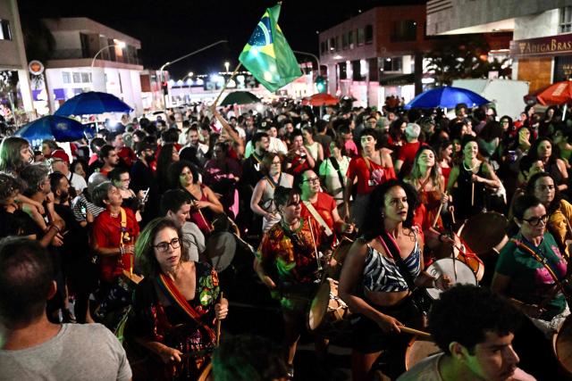 Supporters of the ruling Workers' Party celebrate in the street following the arrest of former President (2019-2023) Jair Bolsonaro, in Brasilia, on November 22, 2025. Ex-President Jair Bolsonaro -who in September had been sentenced to 27 years in prison over a botched coup bid but has yet to begin serving his term- was taken from house arrest into police custody as he is considered a flight risk according to a Supreme Court ruling. (Photo by Evaristo Sa / AFP)