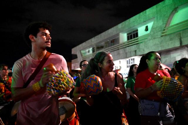 Supporters of the ruling Workers' Party celebrate in the street following the arrest of former President (2019-2023) Jair Bolsonaro, in Brasilia, on November 22, 2025. Ex-President Jair Bolsonaro -who in September had been sentenced to 27 years in prison over a botched coup bid but has yet to begin serving his term- was taken from house arrest into police custody as he is considered a flight risk according to a Supreme Court ruling. (Photo by Evaristo Sa / AFP)