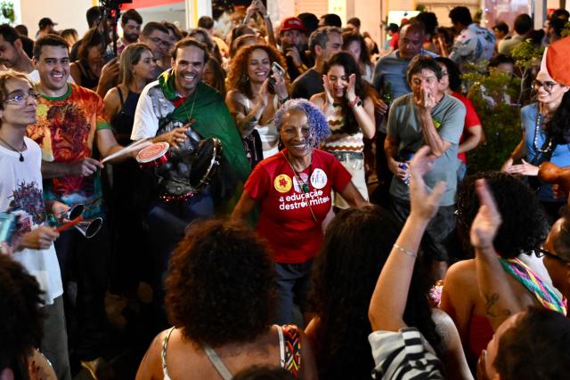 Supporters of the ruling Workers' Party celebrate in the street following the arrest of former President (2019-2023) Jair Bolsonaro, in Brasilia, on November 22, 2025. Ex-President Jair Bolsonaro -who in September had been sentenced to 27 years in prison over a botched coup bid but has yet to begin serving his term- was taken from house arrest into police custody as he is considered a flight risk according to a Supreme Court ruling. (Photo by Evaristo Sa / AFP)