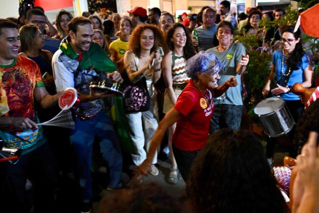 Supporters of the ruling Workers' Party celebrate in the street following the arrest of former President (2019-2023) Jair Bolsonaro, in Brasilia, on November 22, 2025. Ex-President Jair Bolsonaro -who in September had been sentenced to 27 years in prison over a botched coup bid but has yet to begin serving his term- was taken from house arrest into police custody as he is considered a flight risk according to a Supreme Court ruling. (Photo by Evaristo Sa / AFP)