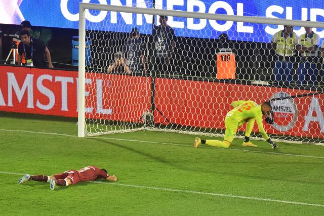 Lanus' forward #07 Lautaro Acosta (L) reacts after failing to score past Atletico Mineiro's goalkeeper #22 Everson (R) during the penalty shootout of the Copa Sudamericana final football match between Argentina's Lanus and Brazil's Atletico Mineiro at the Defensores del Chaco stadium in Asuncion on November 22, 2025. (Photo by JOSE BOGADO / AFP)