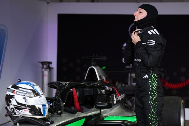 French driver Doriane Pin suits up in her garage before the start of the F1 Academy race at the Las Vega Strip Circuit in Las Vegas, Nevada, on November 22, 2025. (Photo by Patrick T. Fallon / AFP)