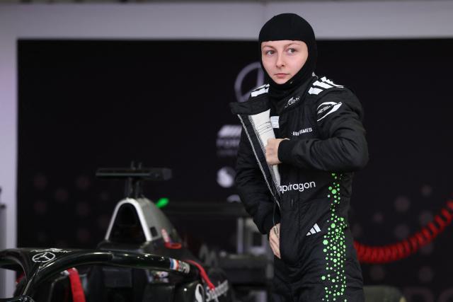 French driver Doriane Pin suits up in her garage before the start of the F1 Academy race at the Las Vega Strip Circuit in Las Vegas, Nevada, on November 22, 2025. (Photo by Patrick T. Fallon / AFP)