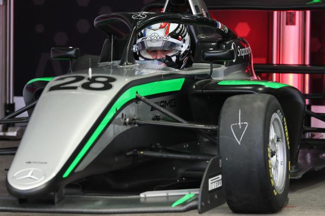 French driver Doriane Pin sits in her car before the start of the F1 Academy race at the Las Vega Strip Circuit in Las Vegas, Nevada, on November 22, 2025. (Photo by Patrick T. Fallon / AFP)
