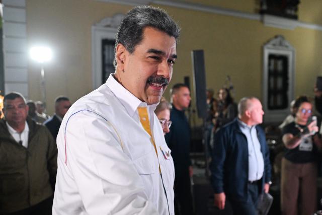Venezuela's President Nicolas Maduro gestures as he arrives for the projection of a biographical series at the National Theatre of Venezuela in Caracas on November 22, 2025. (Photo by Juan BARRETO / AFP)