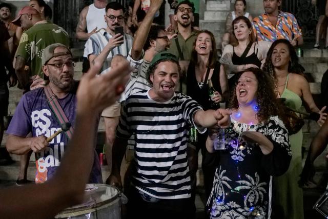 People celebrate in the streets following the arrest of former President Jair Bolsonaro (2019–2023) in Rio de Janeiro, Brazil on November 22, 2025. Ex-President Jair Bolsonaro -who in September had been sentenced to 27 years in prison over a botched coup bid but has yet to begin serving his term- was taken from house arrest into police custody as he is considered a flight risk according to a Supreme Court ruling. (Photo by BRUNO KAIUCA / AFP)
