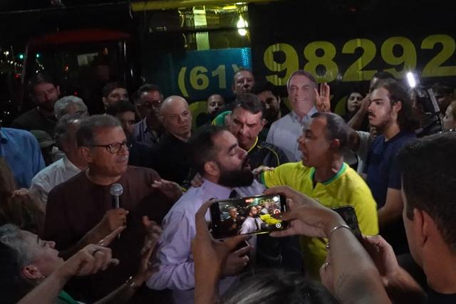 This screen grab taken from AFPTV video footage shows supporters of former Brazil’s President (2019–2023) Jair Bolsonaro clashing with an opponent next to Brazilian Senator Flavio Bolsonaro, son of the former president, during a vigil for his health and freedom in Brasilia on November 22, 2025. Ex-President Jair Bolsonaro -who in September had been sentenced to 27 years in prison over a botched coup bid but has yet to begin serving his term- was taken from house arrest into police custody as he is considered a flight risk according to a Supreme Court ruling. (Photo by Jose OSORIO / AFPTV / AFP)