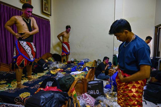 Artists apply makeup and get their costumes ready before taking part in a wayang orang performance, at the Cak Durasim Art Building in Surabaya, East Java province on November 22, 2025. Wayang orang, also known as wayang wong or "human puppet" is a traditional Javanese and Balinese dance theatrical performance where human actors play the roles of puppets to tell storis from Hindu epics such as the Ramayana and Mahabharata. (Photo by Juni KRISWANTO / AFP)