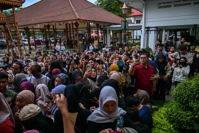 People queue before watching a wayang orang performance, at the Cak Durasim Art Building in Surabaya, East Java province on November 22, 2025. Wayang orang, also known as wayang wong or "human puppet" is a traditional Javanese and Balinese dance theatrical performance where human actors play the roles of puppets to tell storis from Hindu epics such as the Ramayana and Mahabharata. (Photo by Juni KRISWANTO / AFP)