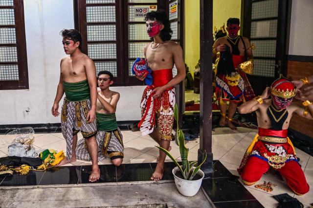 Artists apply makeup and get their costumes ready before taking part in a wayang orang performance, at the Cak Durasim Art Building in Surabaya, East Java province on November 22, 2025. Wayang orang, also known as wayang wong or "human puppet" is a traditional Javanese and Balinese dance theatrical performance where human actors play the roles of puppets to tell storis from Hindu epics such as the Ramayana and Mahabharata. (Photo by Juni KRISWANTO / AFP)
