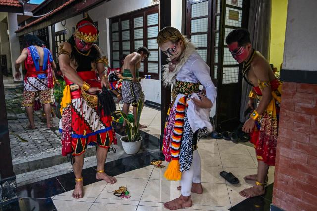 Artists apply makeup and get their costumes ready before taking part in a wayang orang performance, at the Cak Durasim Art Building in Surabaya, East Java province on November 22, 2025. Wayang orang, also known as wayang wong or "human puppet" is a traditional Javanese and Balinese dance theatrical performance where human actors play the roles of puppets to tell storis from Hindu epics such as the Ramayana and Mahabharata. (Photo by Juni KRISWANTO / AFP)