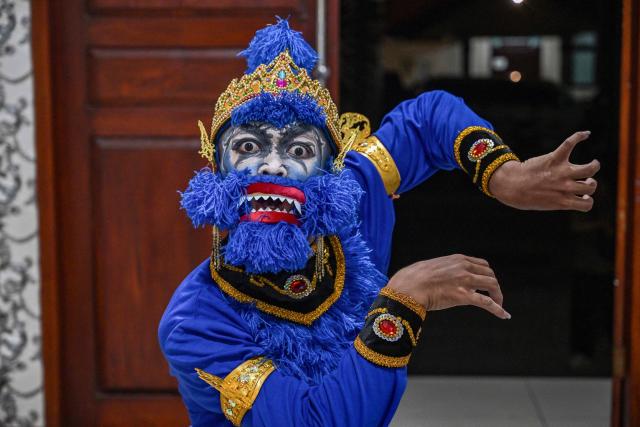 A artist poses in his costumes before taking part in a wayang orang performance, at the Cak Durasim Art Building in Surabaya, East Java province on November 22, 2025. Wayang orang, also known as wayang wong or "human puppet" is a traditional Javanese and Balinese dance theatrical performance where human actors play the roles of puppets to tell storis from Hindu epics such as the Ramayana and Mahabharata. (Photo by Juni KRISWANTO / AFP)