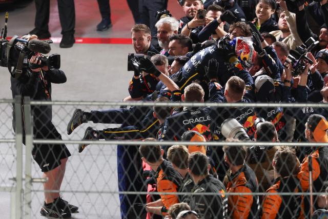 Red Bull Racing's Dutch driver Max Verstappen jumps toward his teammates after winning the Las Vegas Formula One Grand Prix at the Las Vegas Strip Circuit in Las Vegas, Nevada, on November 22, 2025. (Photo by Patrick T. Fallon / AFP)