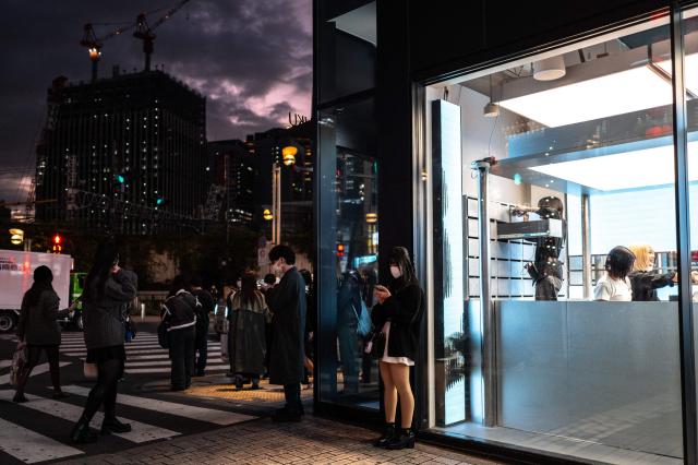 People gather outside a shop in Tokyo's Shinjuku district on November 22, 2025. (Photo by Philip FONG / AFP)