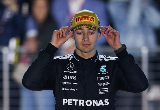 Third place finisher Mercedes' British driver George Russell adjust his hat during the podium ceremony after the Las Vegas Formula One Grand Prix at the Las Vegas Strip Circuit in Las Vegas, Nevada, on November 22, 2025. (Photo by Patrick T. Fallon / AFP)