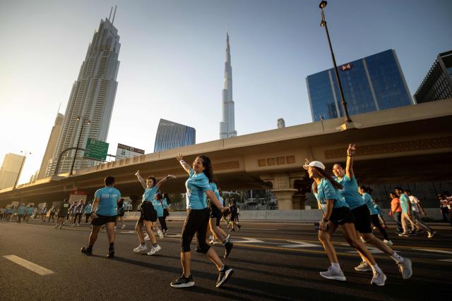 Runners take part in the "Dubai Run 2025" as part of the 9th Edition of Dubai Fitness Challenge, in Dubai on November 23, 2025. (Photo by FADEL SENNA / AFP)