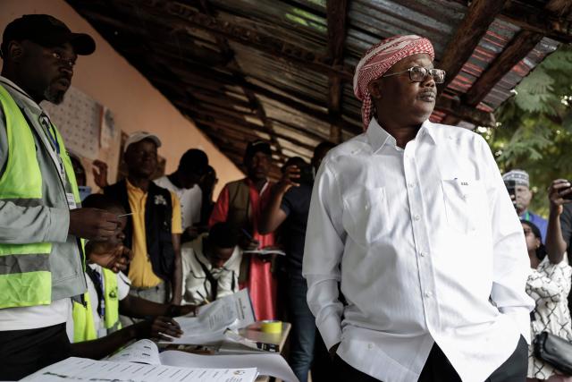 Guinea-Bissau's President and presidential candidate Umaro Sissoco Embalo (R) waits to be registerd by electoral officials before casting his ballot at the Gabu Maternal and Child Center polling station in Gabu on November 23, 2025 during Guinea-Bissau's presidential and legislative elections. (Photo by Patrick MEINHARDT / AFP)