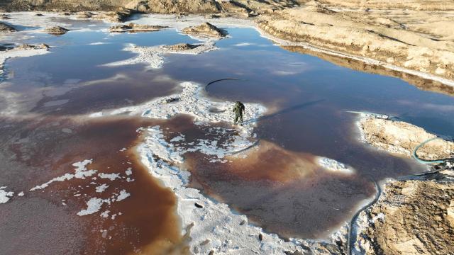 An aerial view shows salt mounds emerging from Lake Najaf or Bahr Al-Najaf (Najaf Sea), an inland lake in southern Iraq, some 10 kilometers southwest of the Iraqi city of Najaf on November 22, 2025. Known as the Najaf Sea, the inland lake has lost more than 10,000 acres of its surface water according to local enviromentalists. The waters, once one of the most important water resources in central Iraq, is deteriorating reflecting a broader pattern of water scarcity driven by upstream damming, climate change, and reduced rainfall. (Photo by Qassem al-KAABI / AFP)