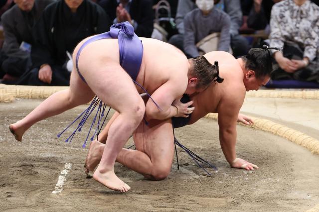 Ukrainian sumo wrestler Danylo Yavhusishyn (L), also known by his Japanese ring name Aonishiki Arata, wins the championship match by defeating Hoshoryu during the Grand Sumo Tournament in Fukuoka on November 23, 2025. (Photo by JIJI PRESS / AFP) / Japan OUT