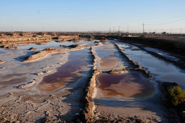 Salt mounds emerging from Lake Najaf or Bahr Al-Najaf (Najaf Sea), an inland lake in southern Iraq, some 10 kilometers southwest of the Iraqi city of Najaf on November 22, 2025. Known as the Najaf Sea, the inland lake has lost more than 10,000 acres of its surface water according to local environmentalists. The waters, once one of the most important water resources in central Iraq, is deteriorating reflecting a broader pattern of water scarcity driven by upstream damming, climate change, and reduced rainfall. (Photo by Qassem al-KAABI / AFP)