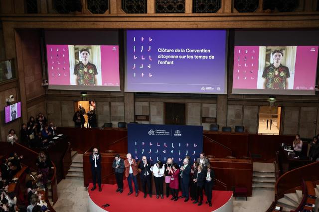 President of the Economic, Social and Environmental Council (CESE) Thierry Beaudet (4thL) aplauds at the ends of session of the CESE citizens' convention on children's time after the adoption of its report, in Paris on November 23, 2025. The citizens' convention on children's time recommends five days of school per week, starting in elementary school, and two holiday zones instead of three to better respect the "biological rhythms of children", according to its final report which is to be formally adopted on November 23, 2025. (Photo by Thibaud MORITZ / AFP)
