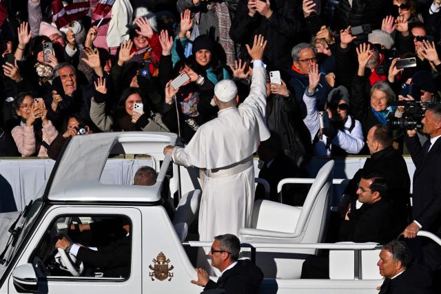 Pope Leo XIV (C) waves to the crowd as he stands on the popemobile while leaving at the end of the Jubilee of Choirs and Choral Society mass at St Peter's Square, in The Vatican, on November 23, 2025. (Photo by Andreas SOLARO / AFP)