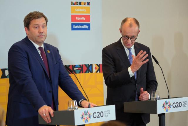 Germany's Vice Chancellor and Finance Minister Lars Klingbeil (L) and German Chancellor Friedrich Merz give a press conference on the sidelines of a G20 Leaders' Summit plenary session at the Nasrec Expo Centre in Johannesburg on November 23, 2025. (Photo by EMMANUEL CROSET / AFP)