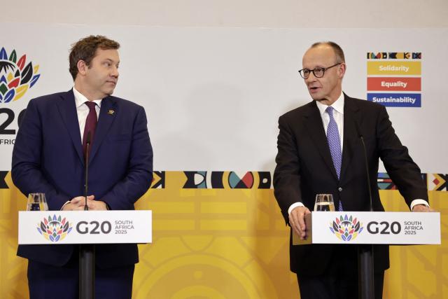 Germany's Vice Chancellor and Finance Minister Lars Klingbeil (L) and German Chancellor Friedrich Merz give a press conference at a hotel in Sandton on November 23, 2025 on the sidelines of the G20 Leaders' Summit. (Photo by EMMANUEL CROSET / AFP)