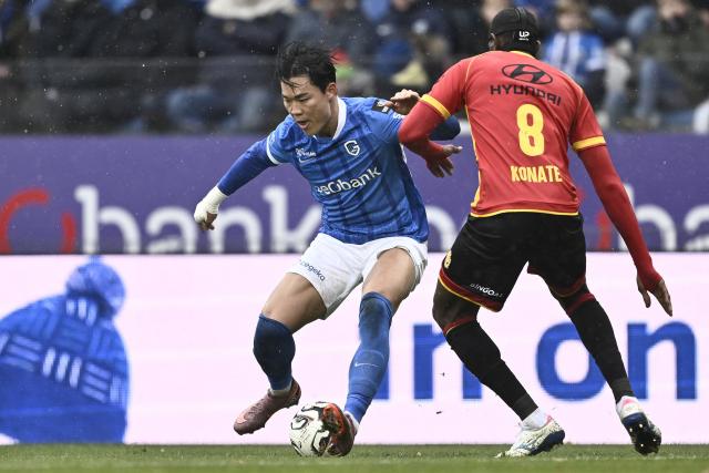 Genk's South Korean forward Hyeon-Gyu Oh (L) fights for the ball with Mechelen's Guinean midfielder Mory Konate during the Belgian Pro League football match between KRC Genk and KV Mechelen, at the Cegeka Arena stadium in Genk, on November 23, 2025. (Photo by Johan Eyckens / Belga / AFP) / Belgium OUT