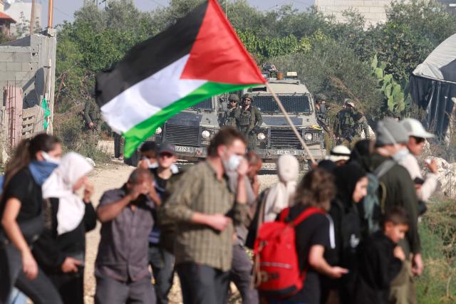 Residents of the Nur Shams refugee camp, near Tulkarem in the Israeli-occupied West Bank, and foreign solidarity activists  gather at the entrance of the camp during a protest demanding the right to return to their homes, on November 23, 2025. Clashes in the territory between Palestinians and the Israeli army or settlers soar after the start of the war in Gaza, which was sparked by the Hamas attack on southern Israel on October 7, 2023. Israel's military launched its operation "Iron Wall" in the north of the West Bank in January, saying it was aimed at cracking down on several camps that are strongholds of Palestinian armed groups fighting against Israel. (Photo by Jaafar ASHTIYEH / AFP)