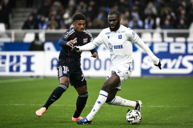 Auxerre's Malian forward #10 Lassine Sinayoko (R) fights for the ball with Lyon's Brazilian defender #16 Vinicius Abner during the French L1 football match between AJ Auxerre and Olympique Lyonnais at the Stade de l'Abbe-Deschamps in Auxerre, central France, on November 23, 2025. (Photo by ARNAUD FINISTRE / AFP)
